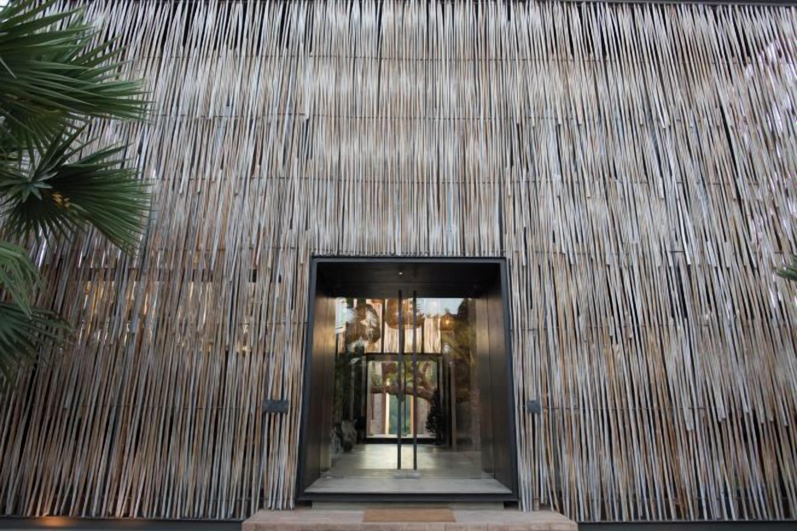 Fachada de edificio con listones de madera verticales y una entrada central.