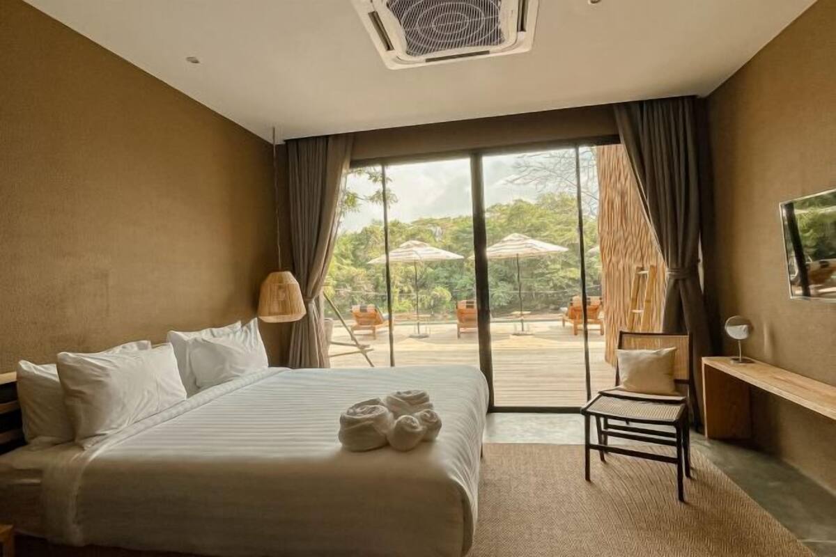 Habitación de hotel con una cama grande, un escritorio y vistas al espacio exterior.