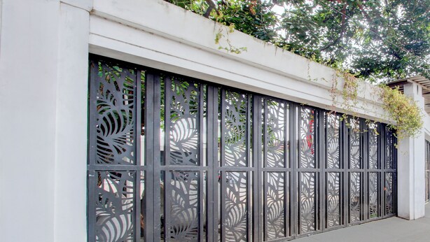 A metal fence with intricate cut-out patterns. - Hotel O Rumah Daun Guesthouse Jogja (Yogyakarta)