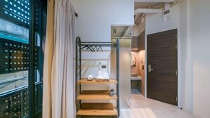 A hallway with a metal rack holding shoes and a wooden shelf with a towel.