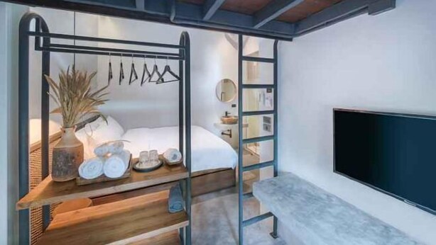 A modern bedroom with a bed, bedside table, and a TV.