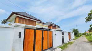 Een modern huis met een witte gevel, een houten deur en een welkomstmat.