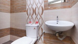 Une salle de bain comprenant des toilettes, un lavabo et un espace douche.