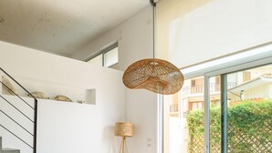 Een moderne eetruimte met een ronde tafel, twee stoelen en een hanglamp.