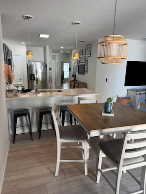 A modern kitchen with a central island, stainless steel appliances, and pendant lighting. - A Fancy Flamingo Historic Downtown Melbourne 5 minute drive Beaches and Airport (Melbourne)
