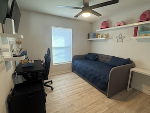 A compact room with a bed, a desk, and a ceiling fan. - A Fancy Flamingo Historic Downtown Melbourne 5 minute drive Beaches and Airport (Melbourne)