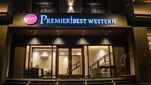 The exterior of a hotel with a prominent sign reading "Premier Best Western."