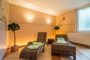 A room with two wicker beds, a small table, two potted plants, and a window with blinds. - Residenzhotel Stuttgart Airport, Sure Hotel Collection by BW (Steinenbronn)
