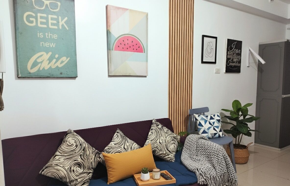 A modern living room with a blue sofa, patterned cushions, and a tray with a plant.