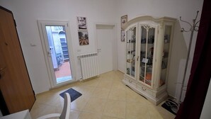 A room with a radiator, a cabinet with glass doors, a door leading to a balcony, and a chair. - dimorarte (Minervino Murge)