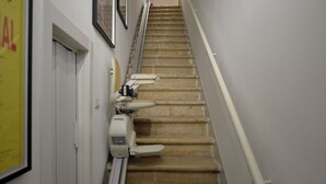 A staircase with a handrail, a wall-mounted object, and a door. - dimorarte (Minervino Murge)