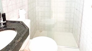 Un baño con ducha, inodoro y lavamanos.