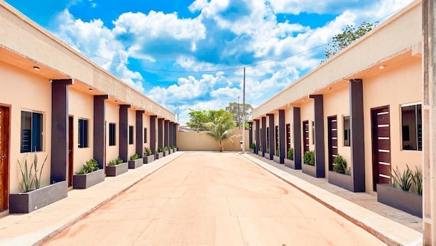 Un edificio moderno con un patio central, que presenta un diseño simétrico con columnas y plantas en macetas.