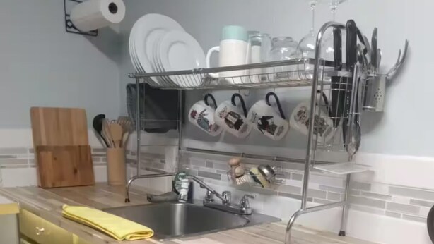 Een keuken met een houten aanrecht, een spoelbak en een afwassysteem erboven.