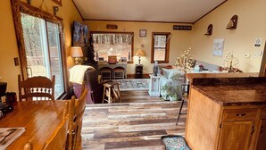Una cocina amplia con una mesa de comedor de madera, un ventilador de techo y un ventanal grande.