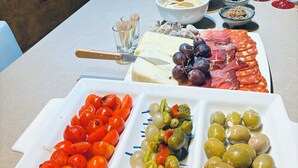 Taula plena d'aliments diversos, una ampolla de xampany i dues flautes.