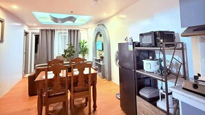 A modern kitchen with a dining area, wooden furniture, and a ceiling with skylights. - The Terrace condominium baguio city (Baguio)