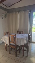 Un comedor con una mesa cubierta por un mantel blanco, rodeado de sillas de madera.