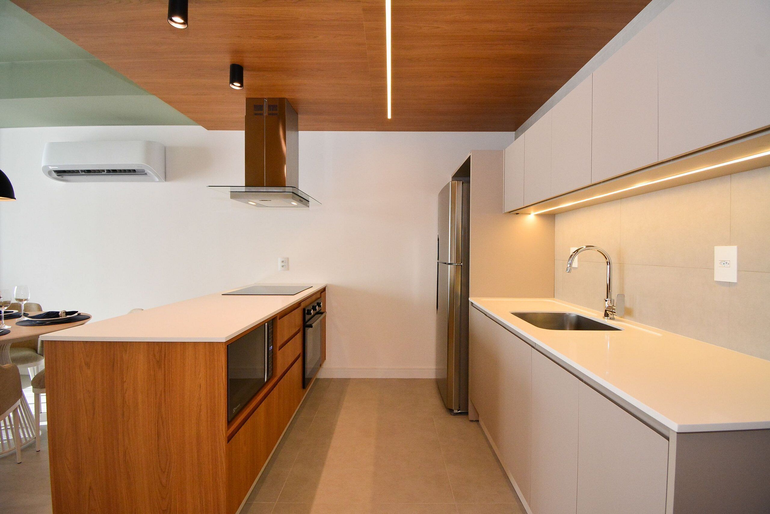 A modern kitchen with a wooden island, stainless steel appliances, and under-cabinet lighting.