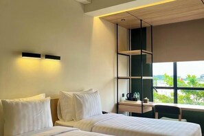 Een moderne hotelkamer met een bed, een bureau en een raam met uitzicht.