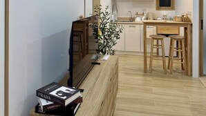 Eine moderne Küche mit Holzausstattung, einer zentralen Kochinsel mit Barhocker und einem Essbereich.