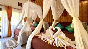 A room with a bed under a canopy, pillows, and a decorative swan made of towels. - Meket Bungalows (Bali)