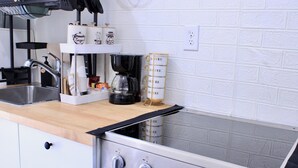 A kitchen with a stainless steel stove, a coffee maker, and a coffee storage unit. - Entire studio w/private entrance near Hwy, Playgrounds and parks (Richmond)