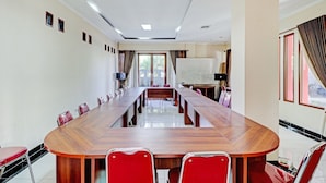 A conference room with a long wooden table, red chairs, and a whiteboard. - OYO 94837 Apartment Ekki Tower (Gunung Putri)
