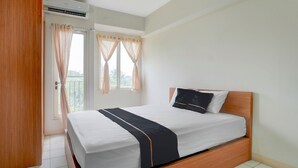 A bedroom with a bed, curtains, and an air conditioning unit. - OYO 94837 Apartment Ekki Tower (Gunung Putri)