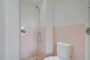 A small, enclosed shower area with a toilet and a showerhead. - OYO 94837 Apartment Ekki Tower (Gunung Putri)