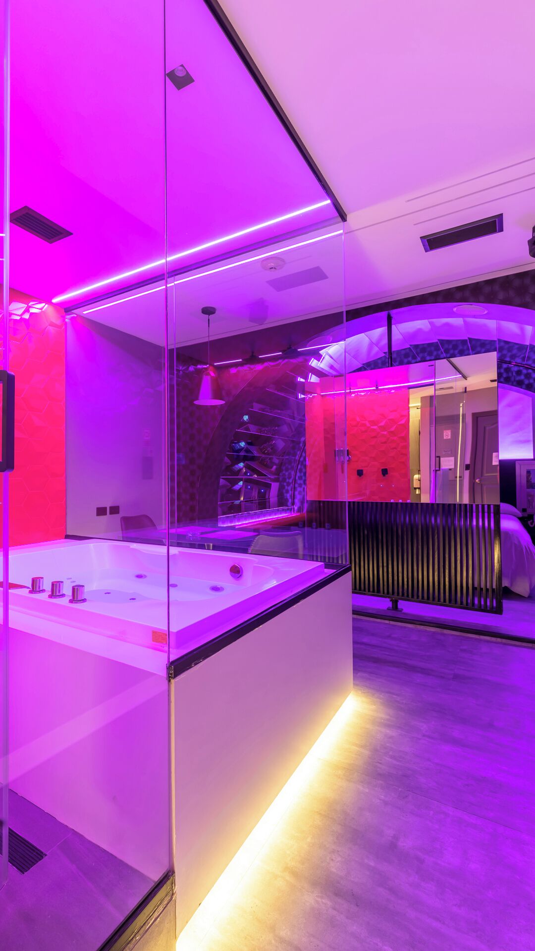 Un baño moderno con separador de vidrio, un lavamanos blanco y un espejo.