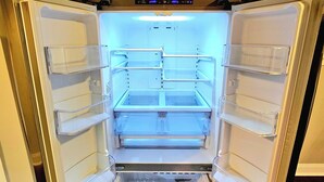 Een open koelkast met meerdere planken en een digitaal scherm.