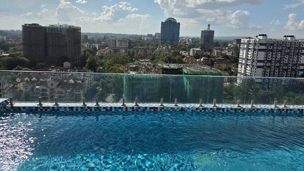 A rooftop pool with a cityscape view, including high-rise buildings and a clear sky. - Marina Bay Suites (Nairobi)