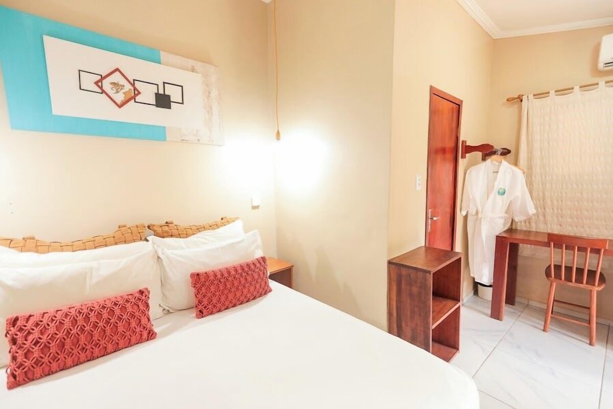 Una habitación de hotel con una cama, un escritorio y una silla.