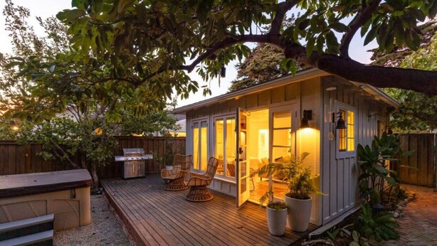 A wooden deck with outdoor furniture, a grill, and a small shed with a door open. - Montecito Orchard Cottage (Montecito)