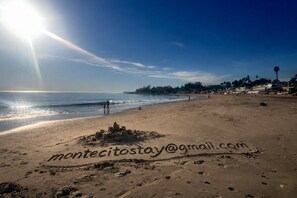 A beach with footprints and a sandcastle, and a clear sky. - Montecito Rose Cottage (Montecito)