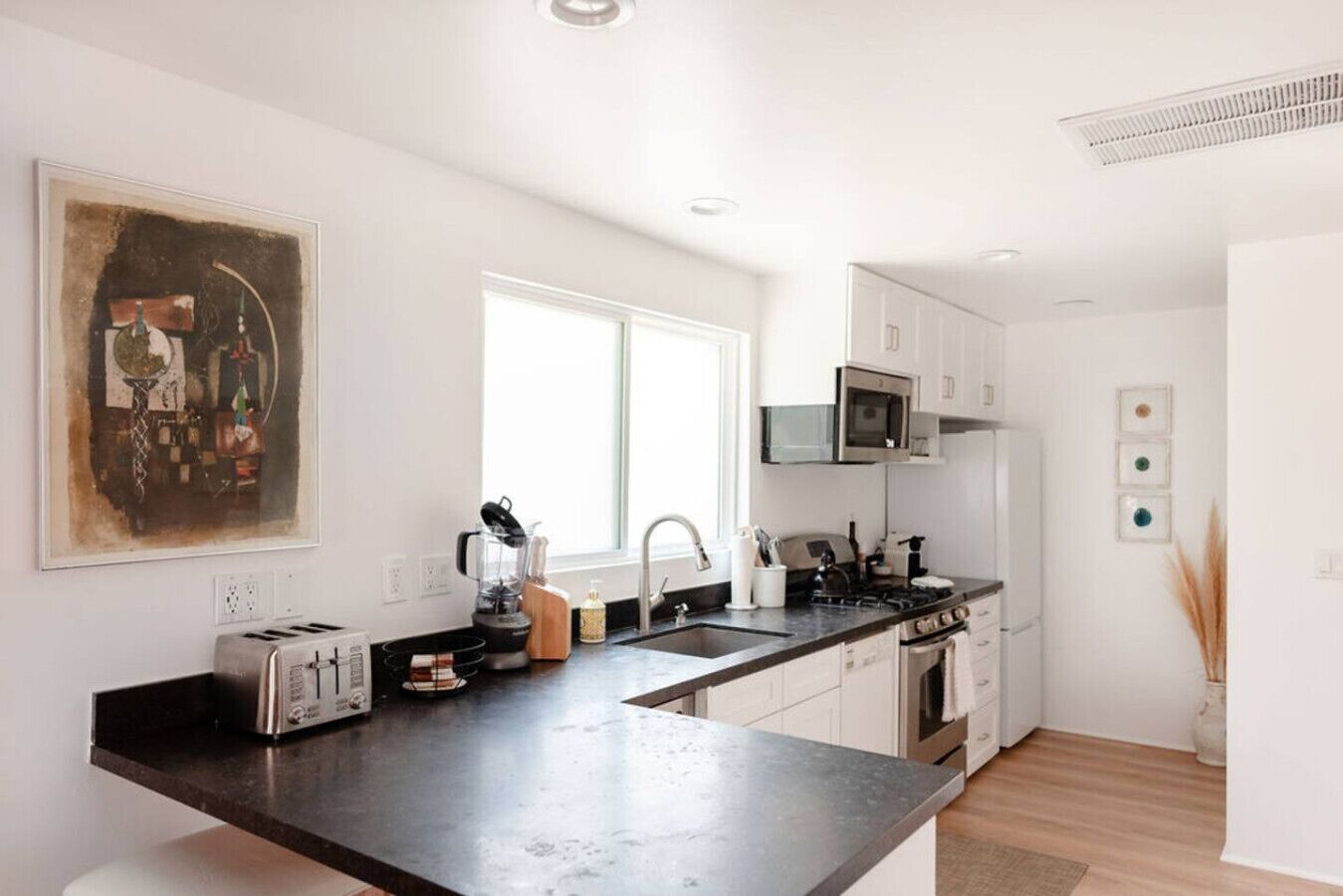 A modern kitchen with a large island, stainless steel appliances, and a minimalist design.