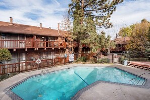 A rectangular swimming pool with a tiled edge, surrounded by a concrete deck. - Snow Summit Cabin Big Bear- 25ft to Snow Summit! (Big Bear Lake)