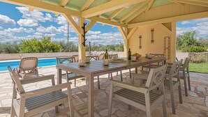 An outdoor patio with a pool, a table set for dining, and chairs. - 4-bedroom villa in beautiful Ljubotić with AC, Rural Villa Olive Krka (Ljubotić)