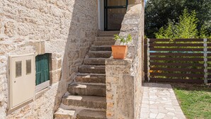 A stone staircase leading to a door, a potted plant on the steps, and a wooden fence in the background. - 4-bedroom villa in beautiful Ljubotić with AC, Rural Villa Olive Krka (Ljubotić)
