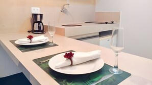 A modern kitchen with a built-in stove, a coffee maker, and a sink. - 119 Ambassador  (Joao Pessoa)