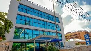 A modern building with a glass facade and a covered entrance area. - 119 Ambassador  (Joao Pessoa)
