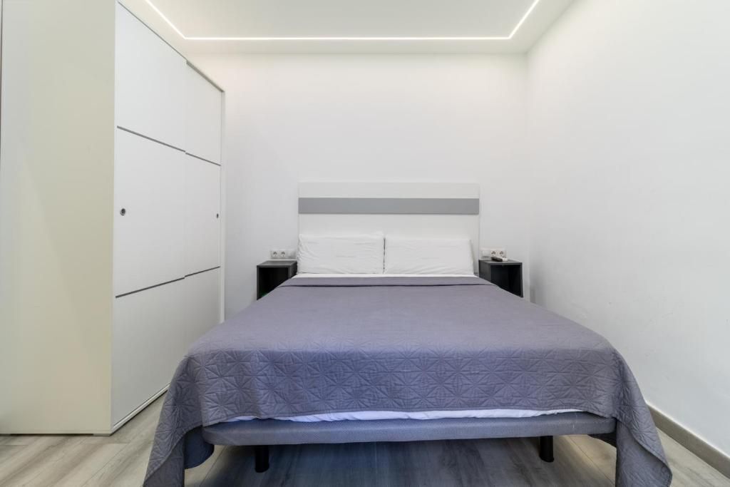 Een slaapkamer met een bed, nachtkastjes en een kledingkast.