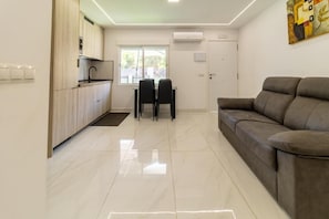 A modern kitchen with a dining area, a sofa, and a window. - Villa Amir (Fuengirola)