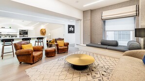 A modern living room with leather sofas, a coffee table, and a patterned rug. - Chic Pimlico Escape with Style & Comfort (London)