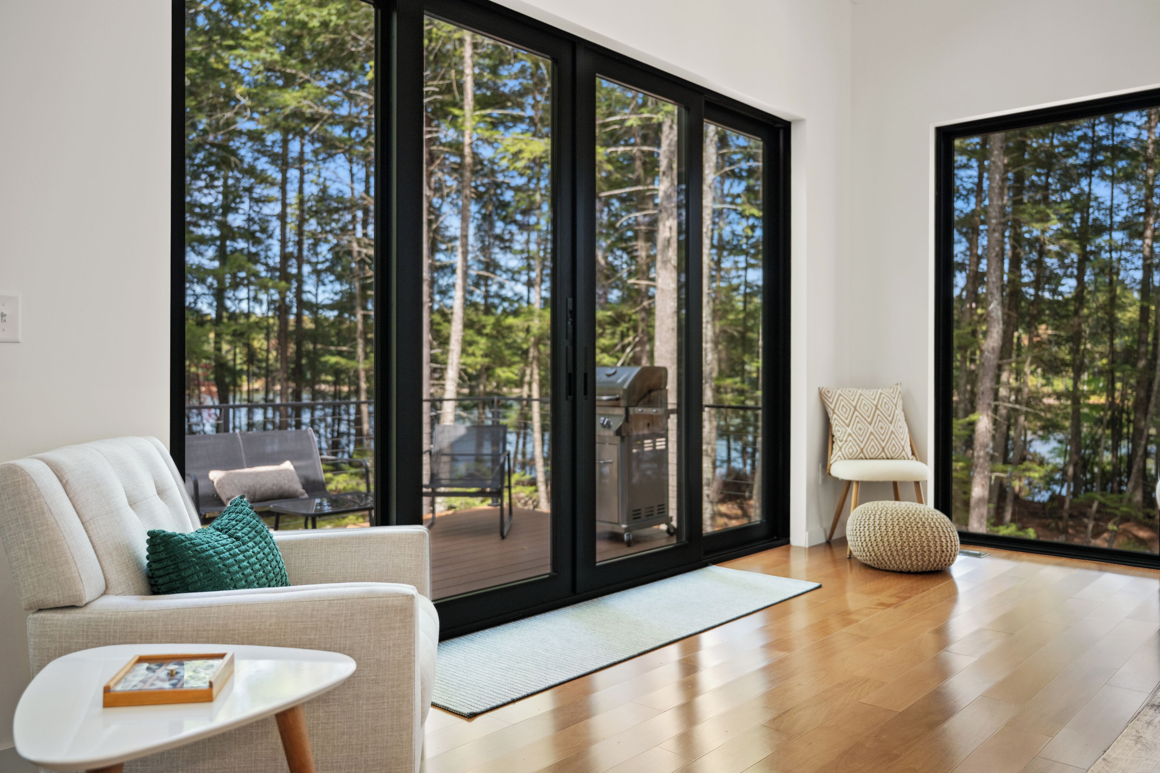 A modern living room with a large sliding glass door leading to an outdoor deck.