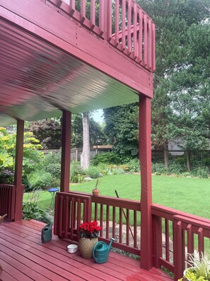 A red wooden deck with a pergola, potted plants, and a small table. - Charming historic home close to the World Cup (Atlanta)