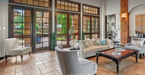 A spacious living area with a large window, a sofa, a coffee table, and a chair. - Landing Furnished Apartments Northwest Houston  (Houston)