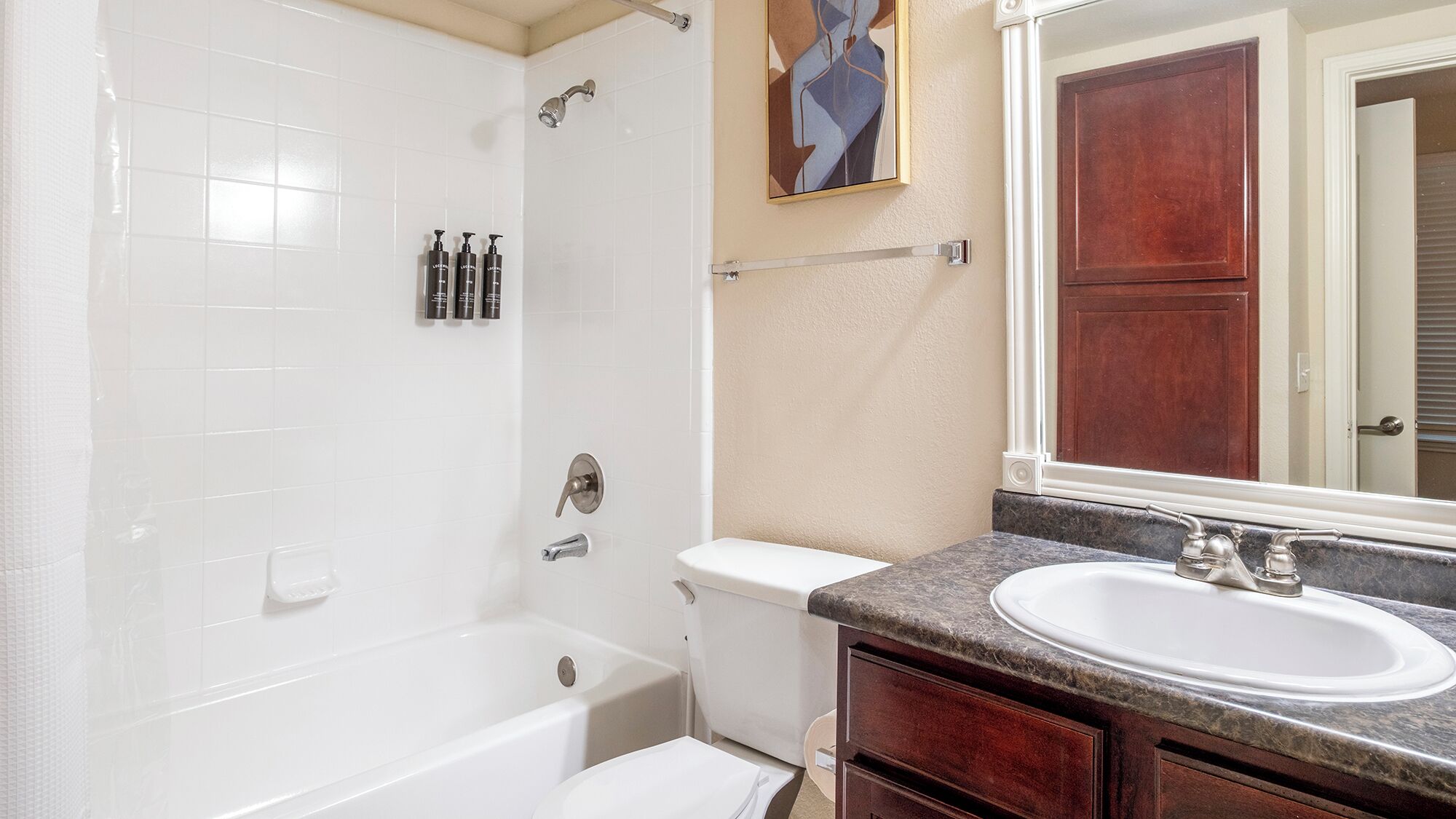 A bathroom with a bathtub, toilet, and sink.