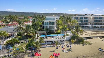 A resort with a pool, beach, and multiple buildings.